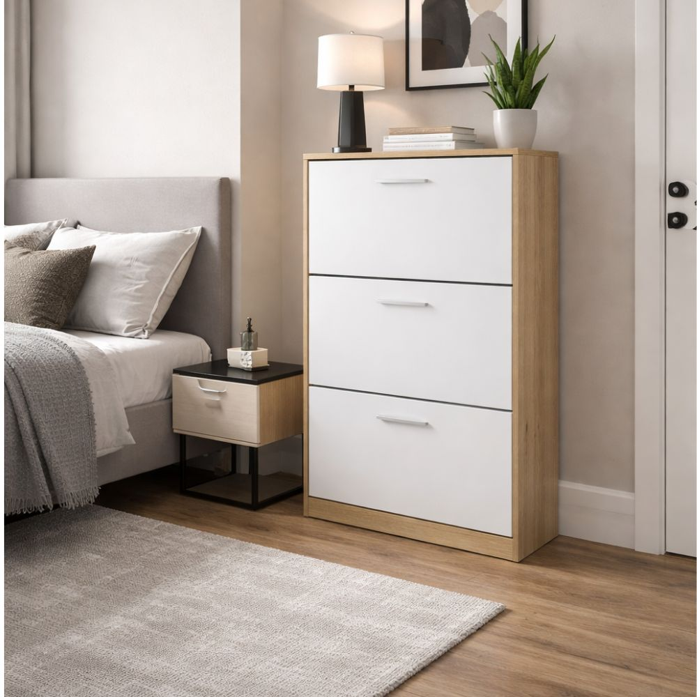 Camera da letto con letto, comodino e mobile bianco a tre cassetti.