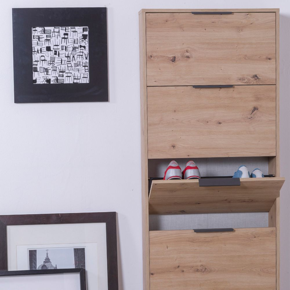 Mobile scarpiere in legno con tre cassetti, due paia di scarpe sullo sportello inferiore.