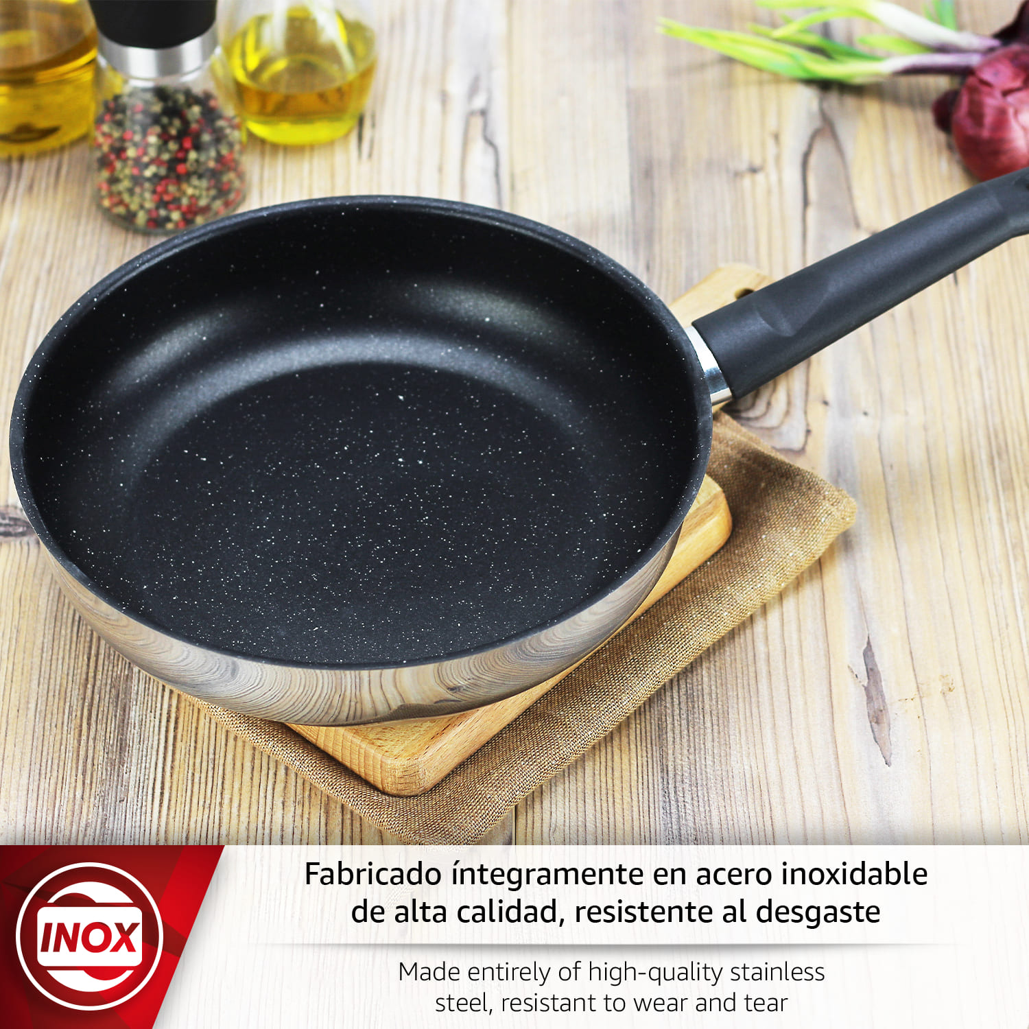 Una sartén negra con borde de acero inoxidable sobre mesa de madera con especias.