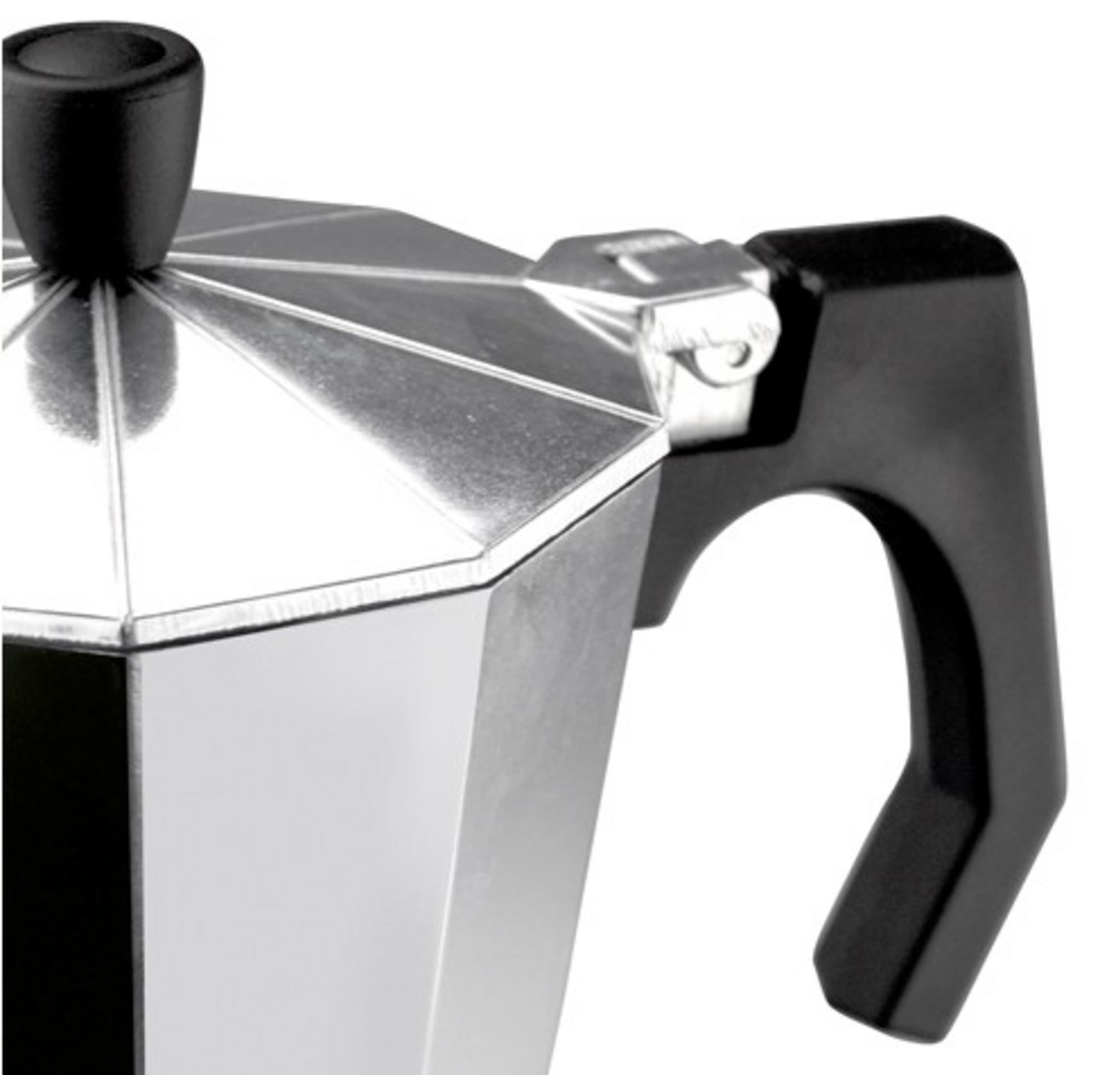 Primer plano de una cafetera moka plateada con asa y pomo negros.