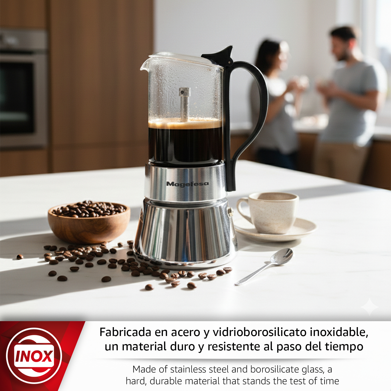 Cafetera de acero inoxidable con cristal, junto a granos de café y una taza.