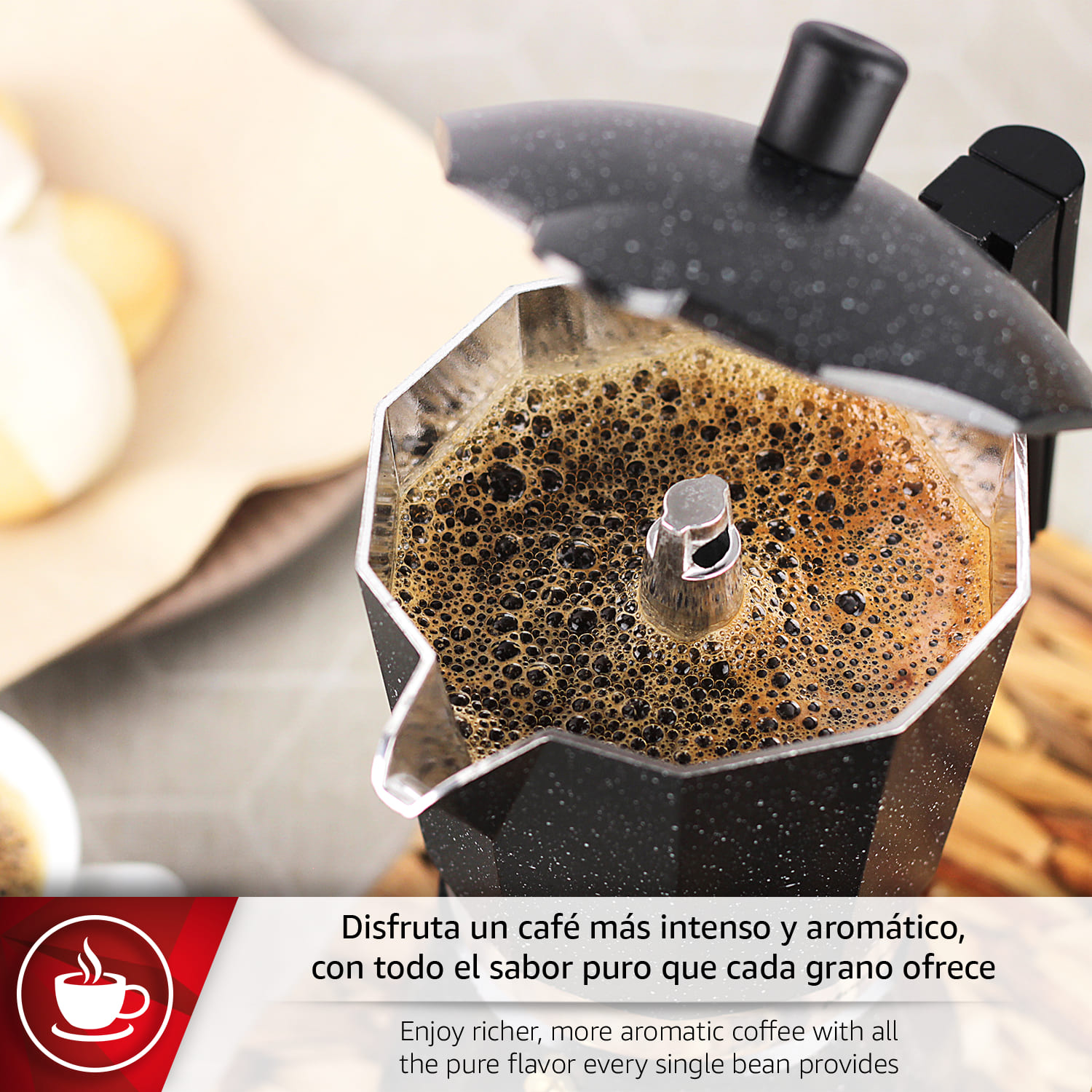 Una cafetera moka negra prepara café caliente con espuma encima.