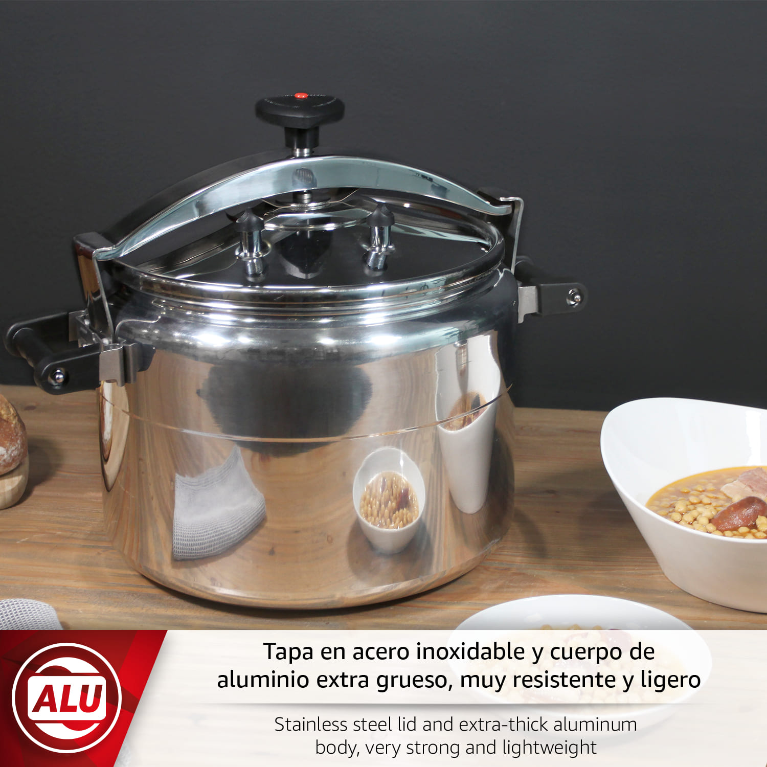 Una olla brillante de acero inoxidable con asas y un pomo negro sobre una mesa de madera.
