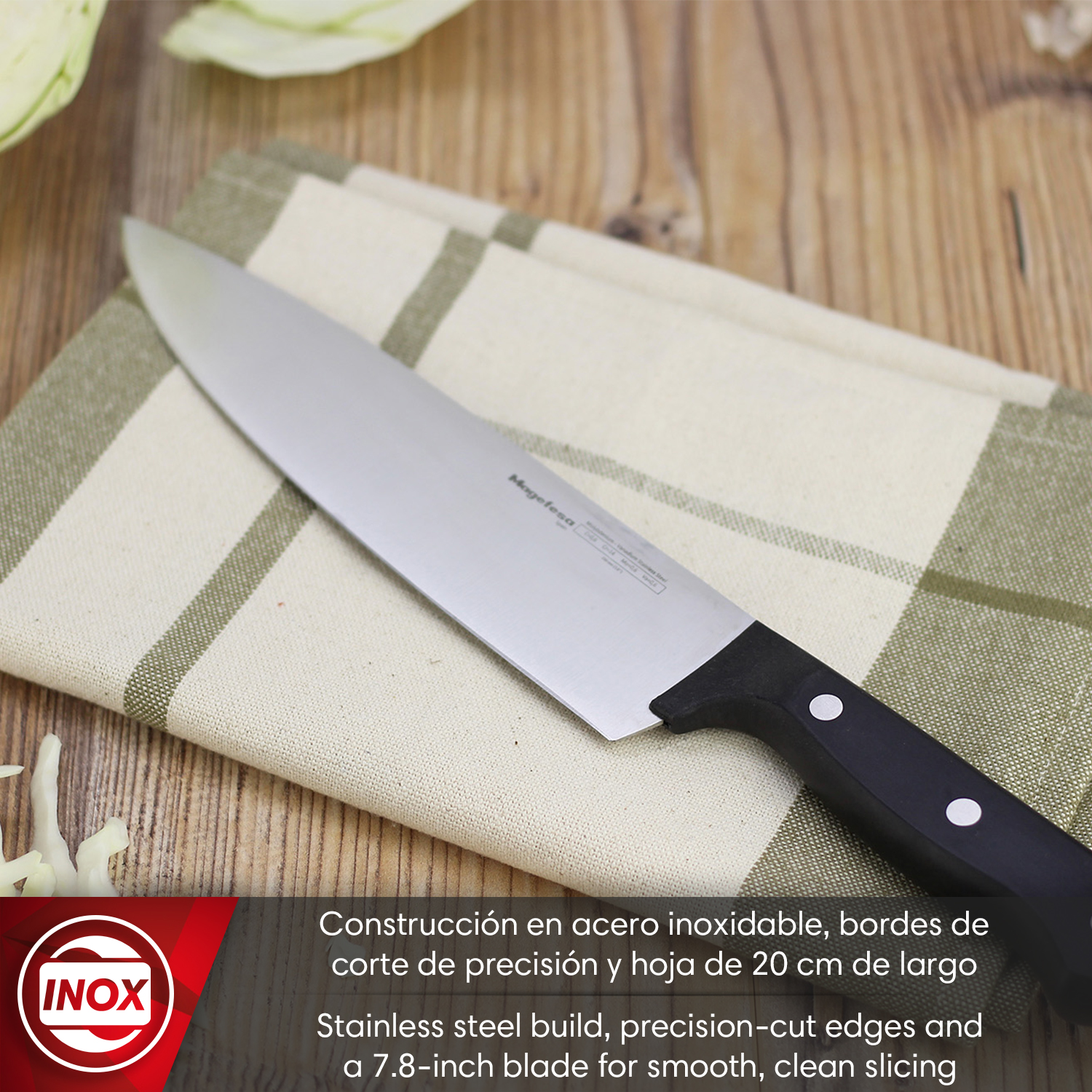 Un cuchillo de acero inoxidable con mango negro sobre un paño a cuadros.
