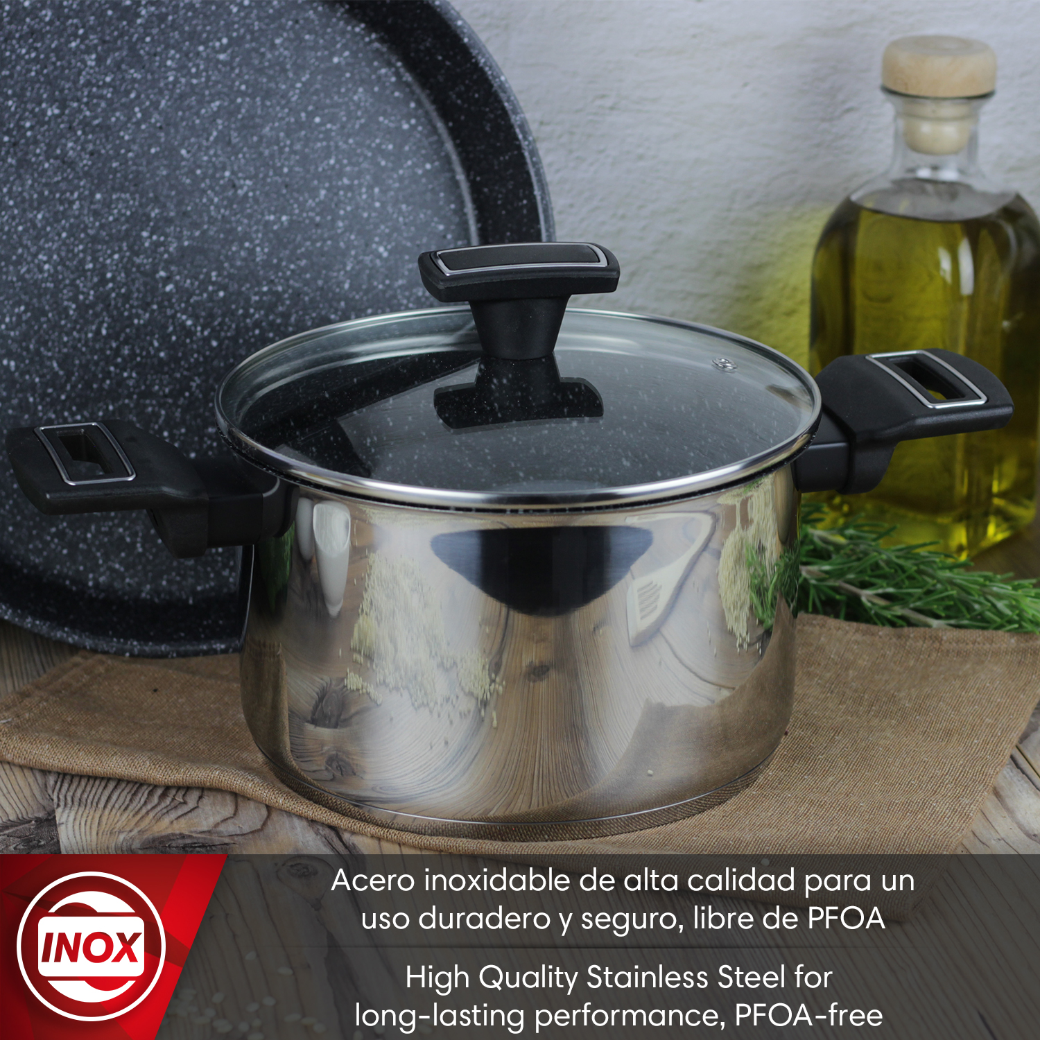 Olla de acero inoxidable con tapa de cristal, al lado botella de aceite y sartén.