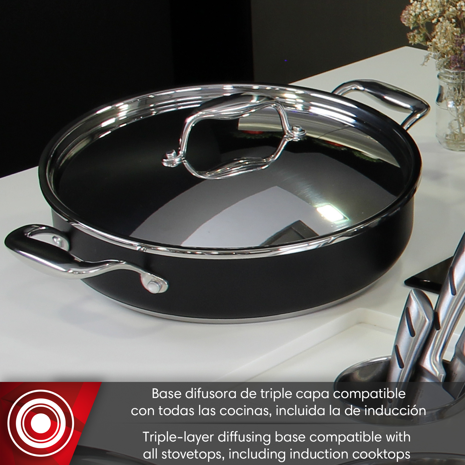 Una olla negra con tapa brillante y dos asas está sobre una superficie blanca.