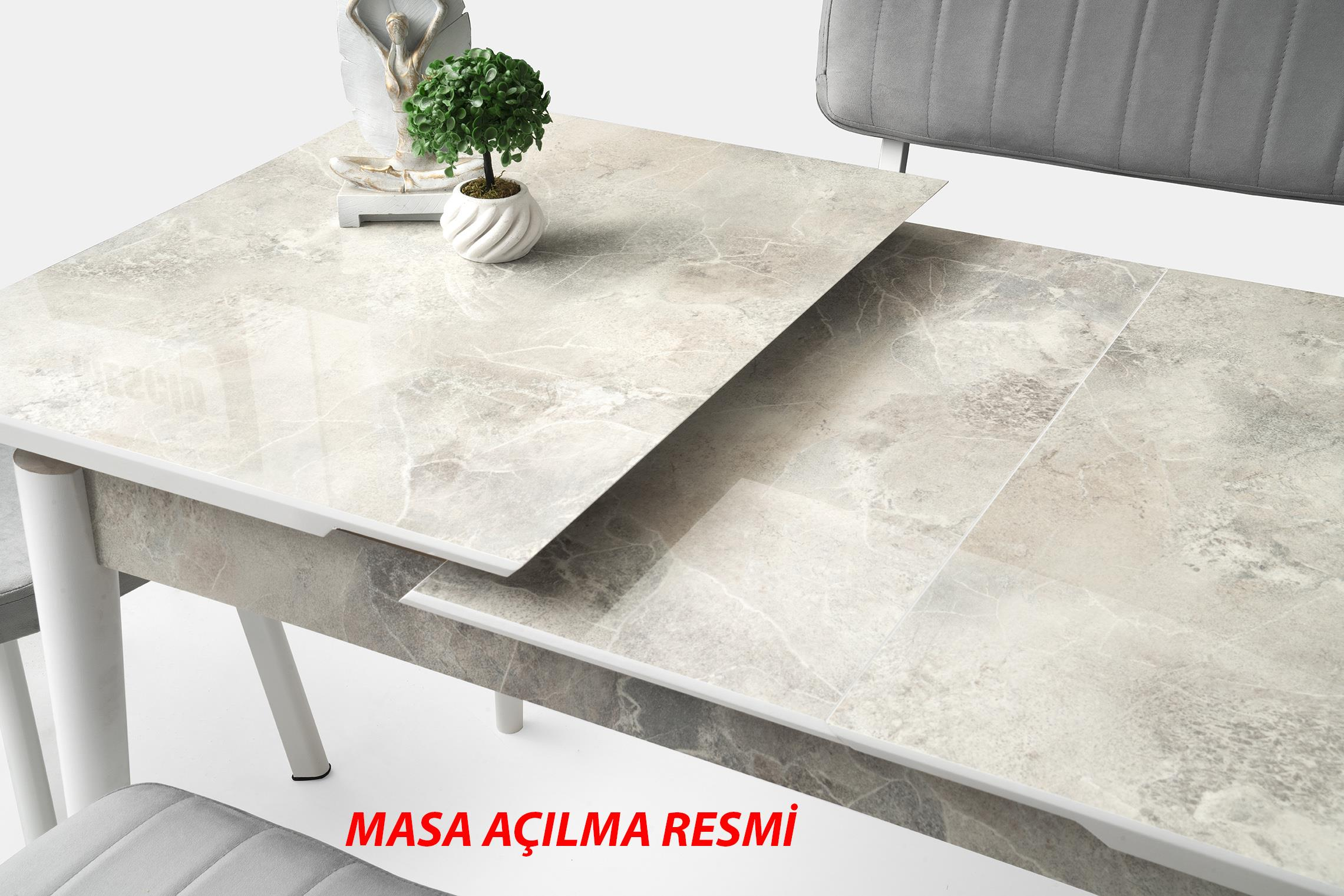 Mermer görünümlü açılabilir masa ve yanında gri sandalyeler.