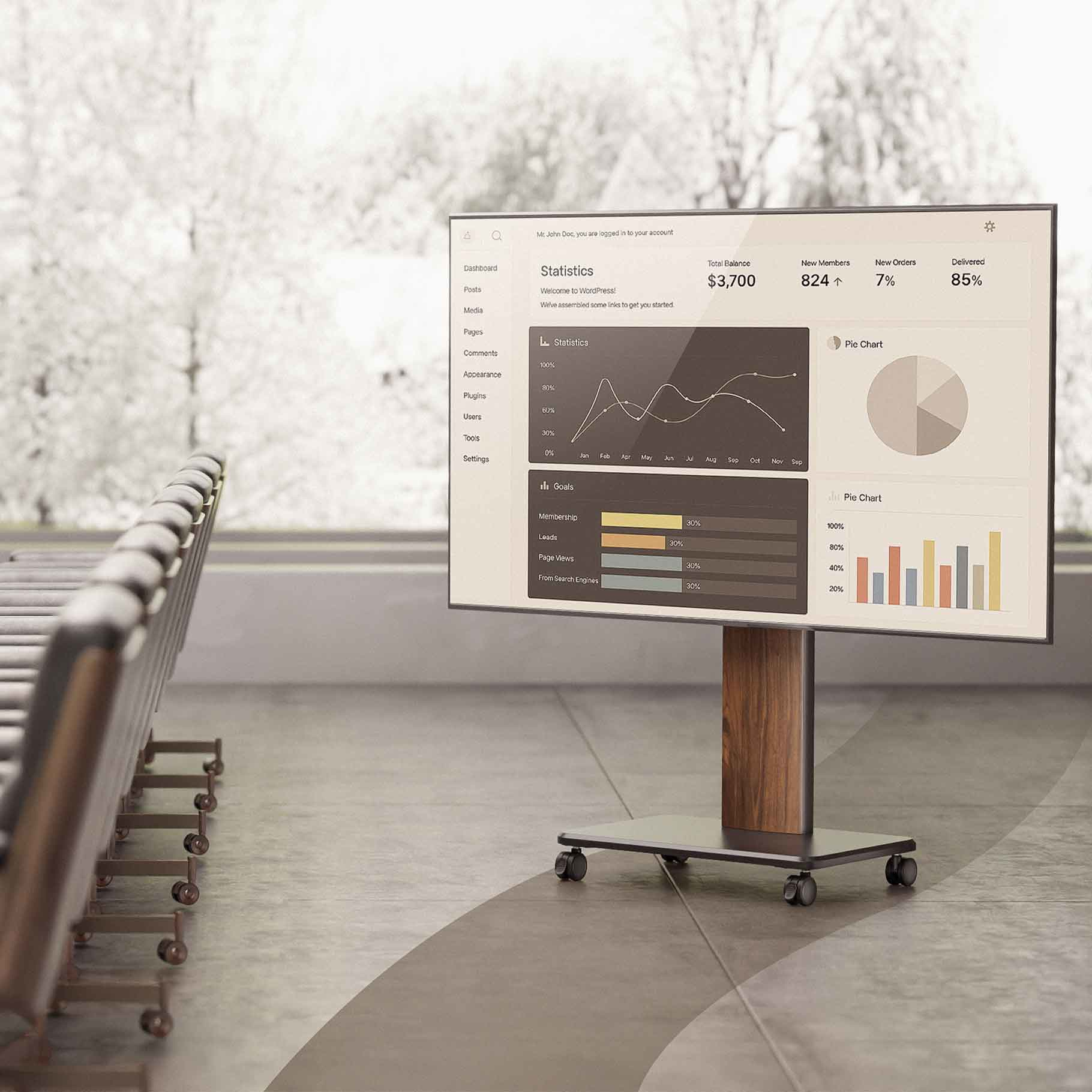 A monitor on a stand displays a dashboard with charts and statistics.