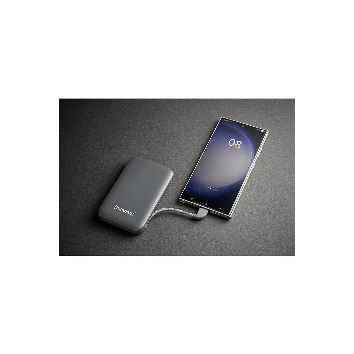 Un power bank grigio carica uno smartphone con l'ora visualizzata.