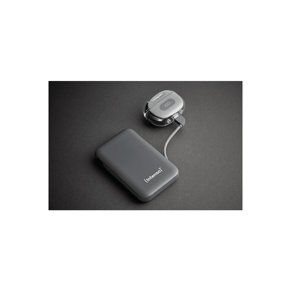 Due dispositivi Intenso grigi, un power bank e un piccolo caricatore, su una superficie grigio scuro.
