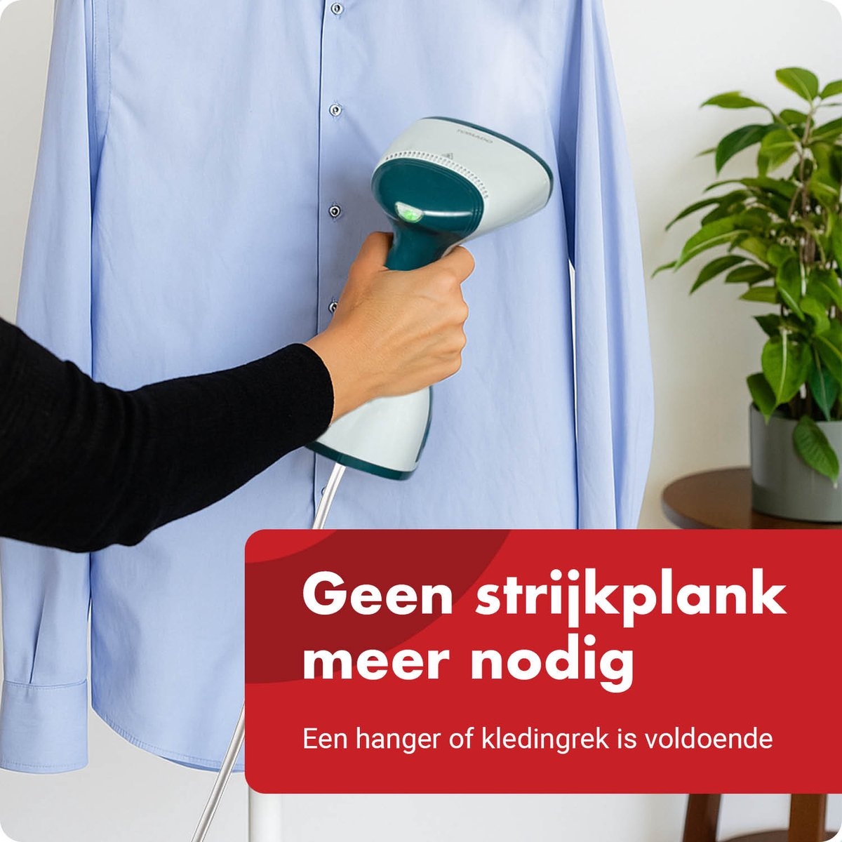 A hand uses a garment steamer to iron a light blue shirt.