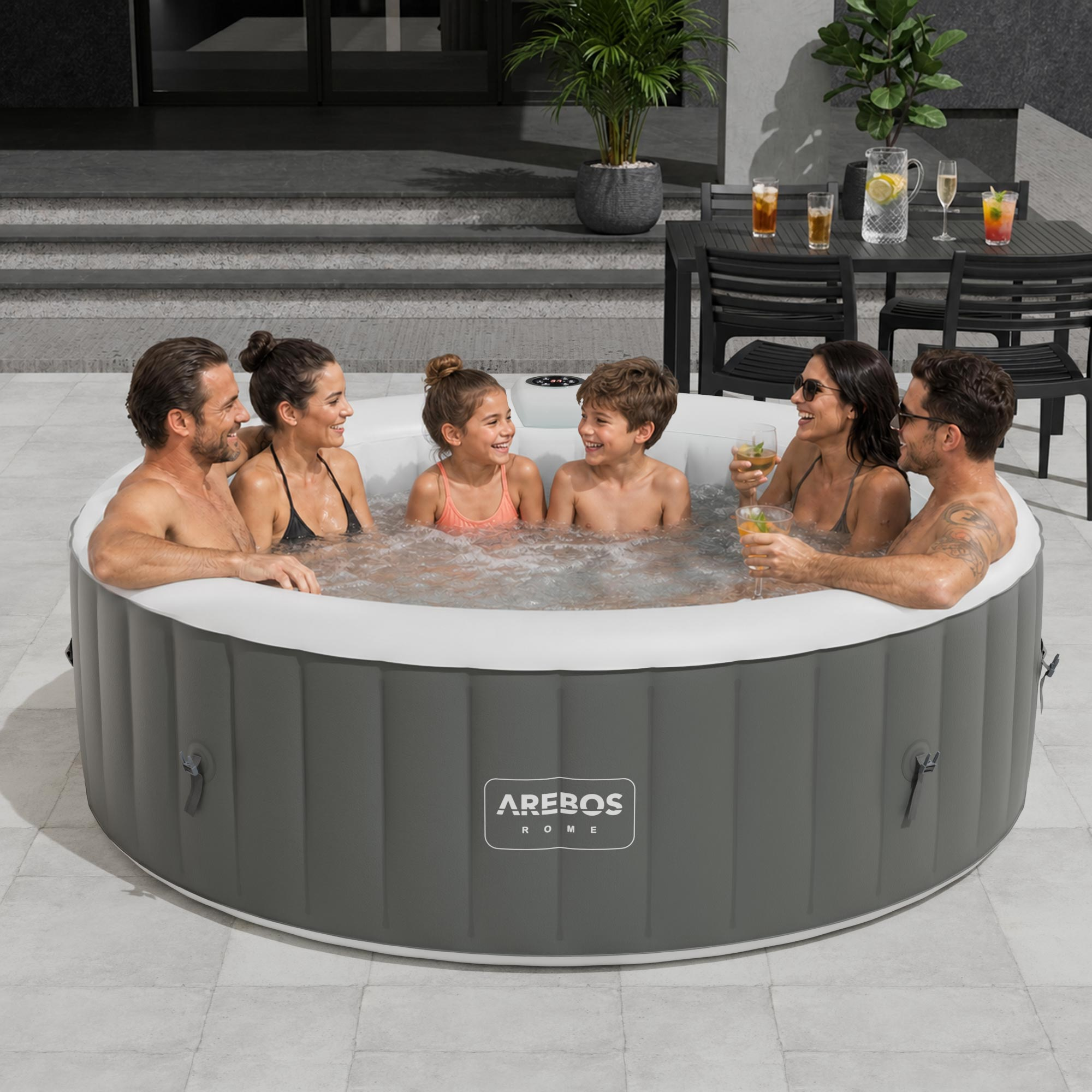 Sechs Personen entspannen sich in einem aufblasbaren Whirlpool im Freien bei Sonnenuntergang.
