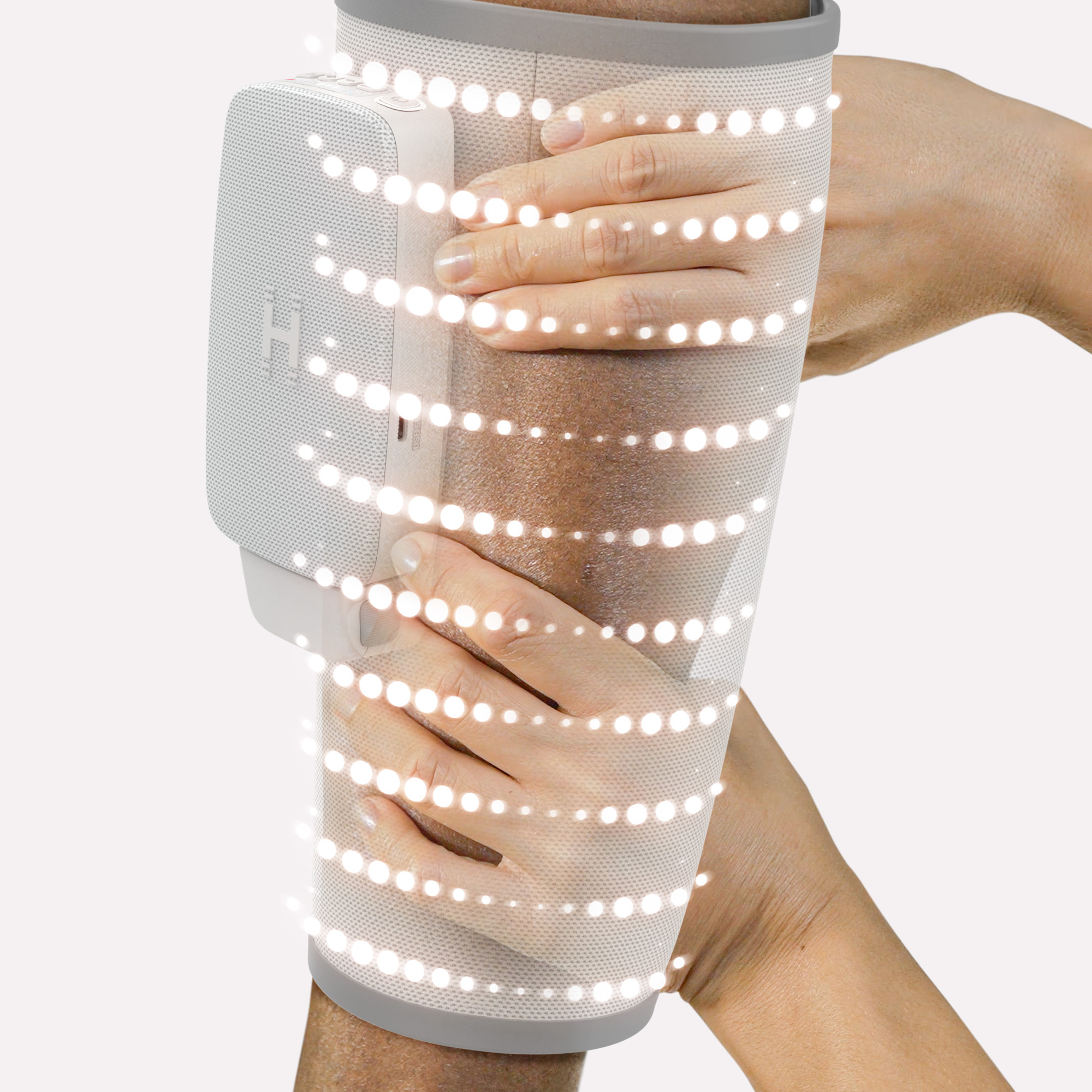 Zwei Hände halten ein weißes Gerät mit Lichtern, das auf einem Arm sitzt.