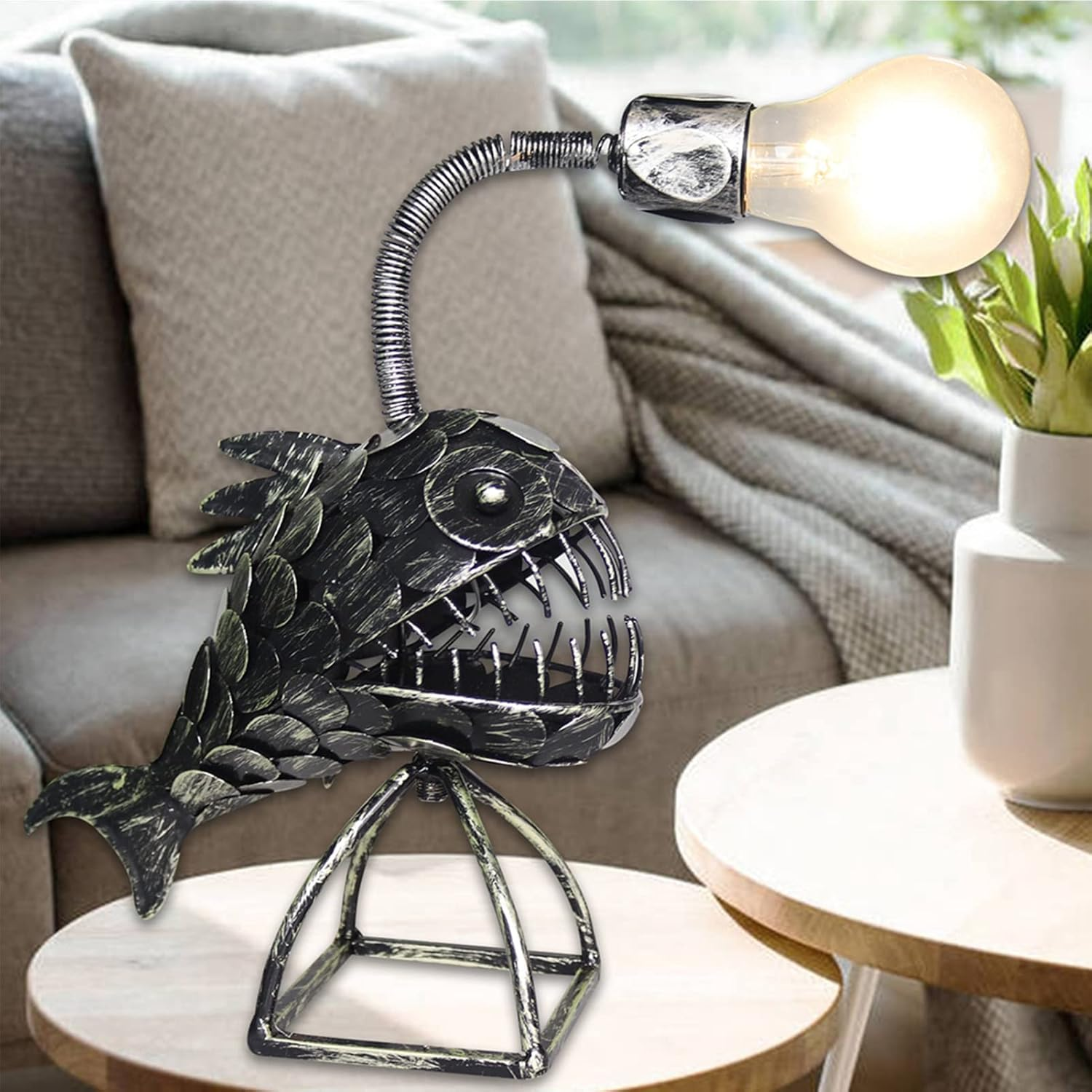 Eine Lampe in Fischform mit Glühbirne steht auf einem Tisch.