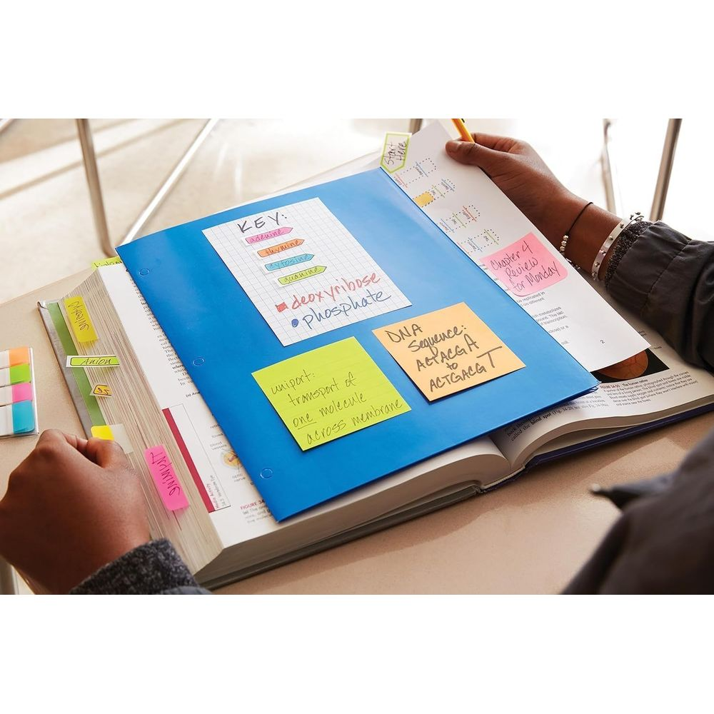 Un livre avec des notes autocollantes colorées et des notes sur l'ADN et la biologie.