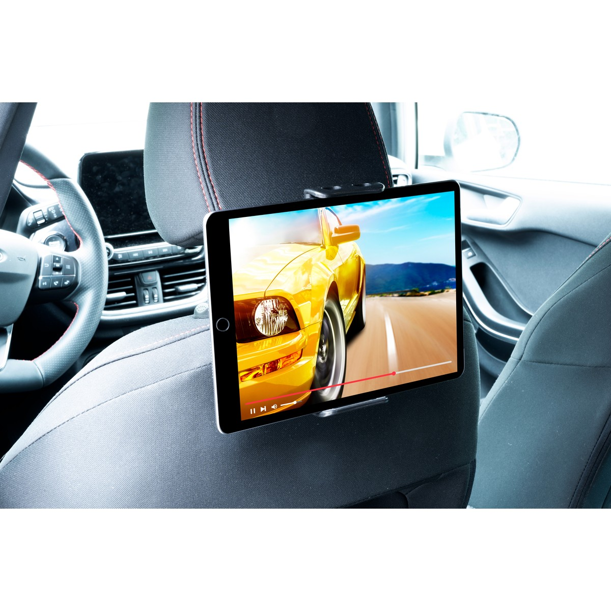 Tablette dans la voiture montre une voiture de sport jaune sur la route, zone conducteur visible.