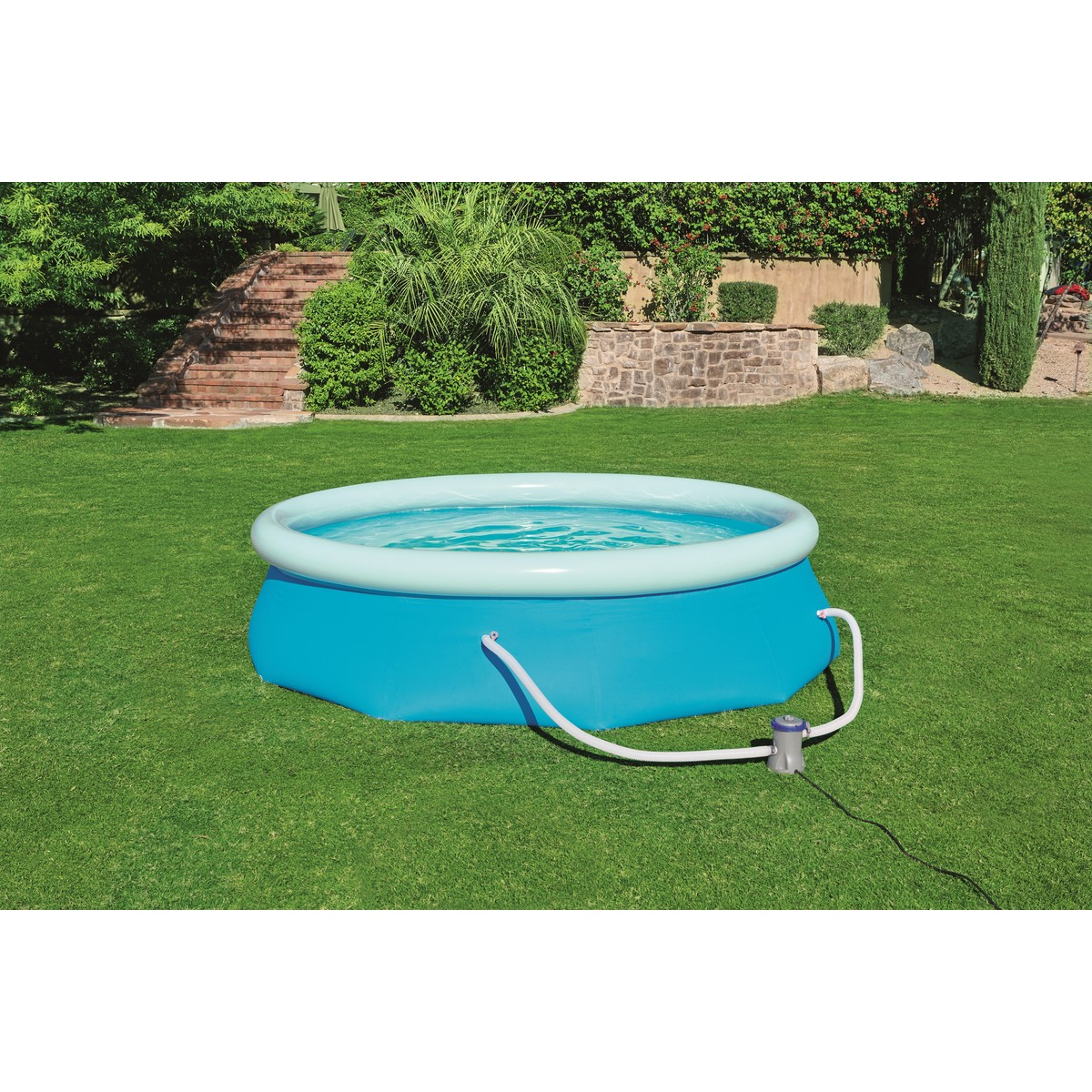 A blue inflatable pool sits on green grass with a pump attached.