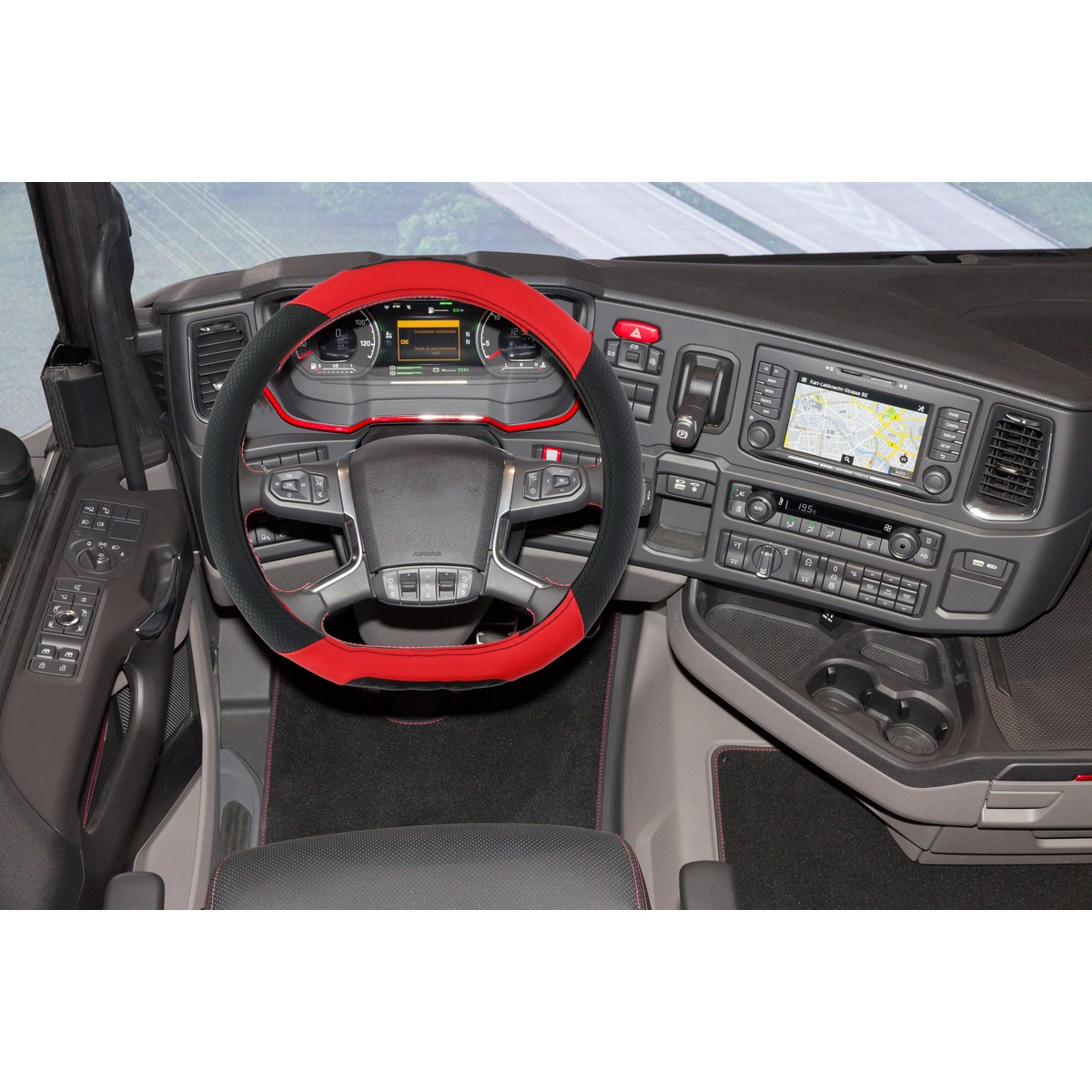Truck interior with a red steering wheel cover, dashboard, and GPS display.