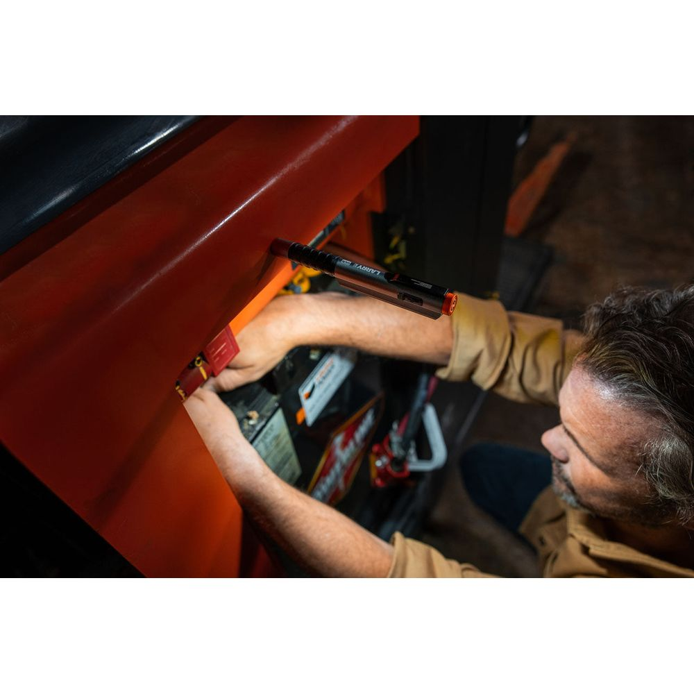 Mann repariert eine Batterie mit einem Lichtstift, der an einer orangefarbenen Verkleidung befestigt ist.