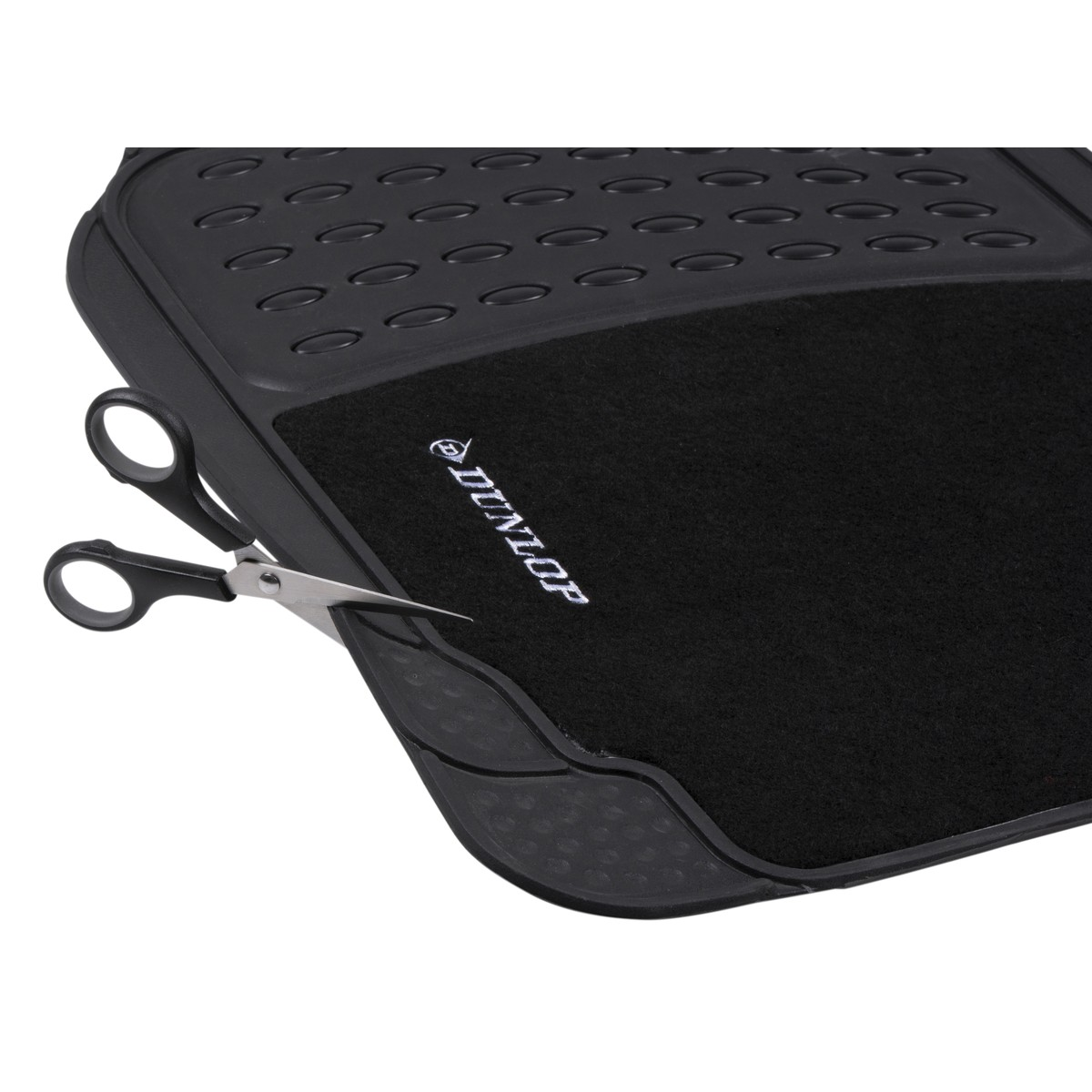 Black car mat with Dunlop logo being cut by scissors.