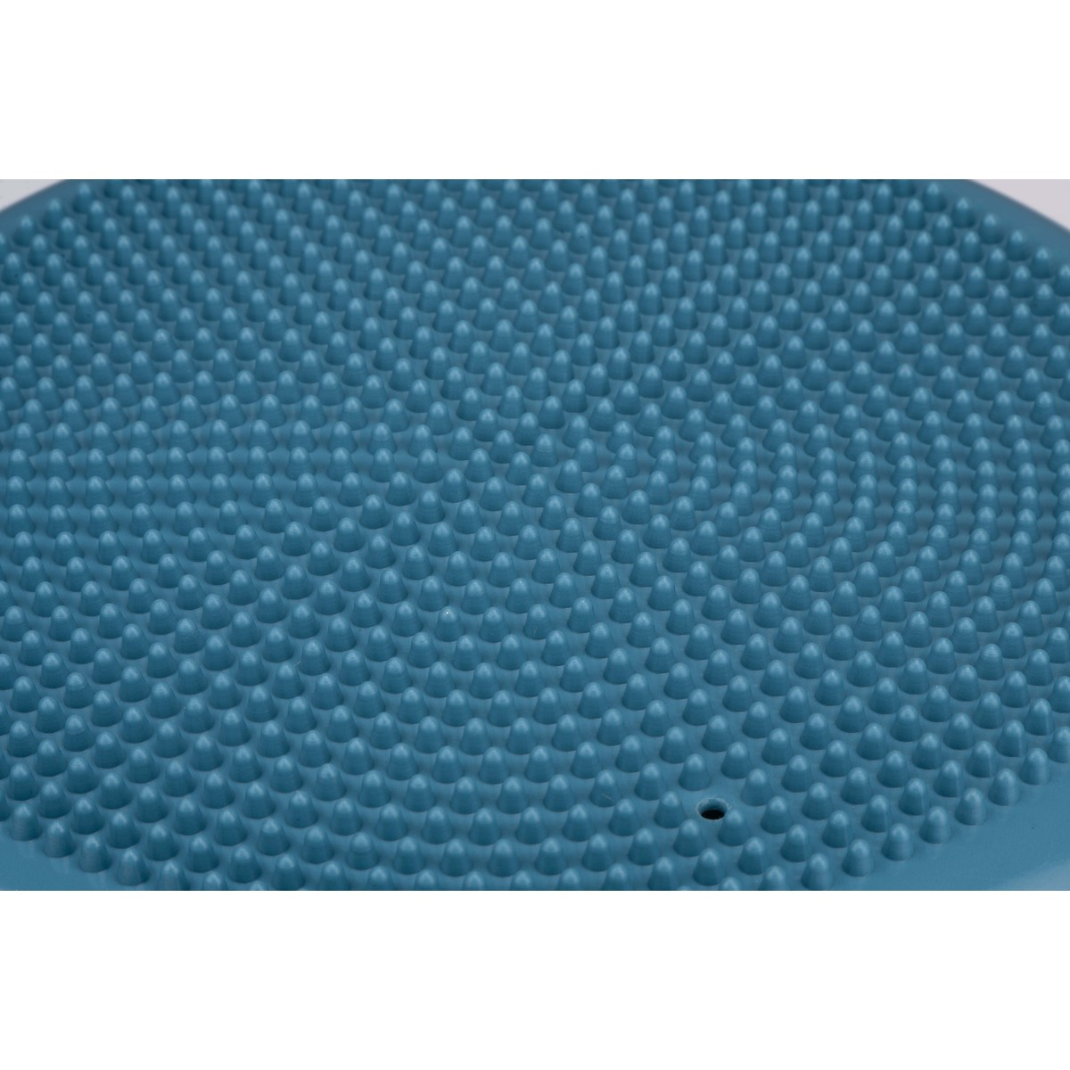 Primo piano di un disco da equilibrio blu con protuberanze rialzate sulla superficie.