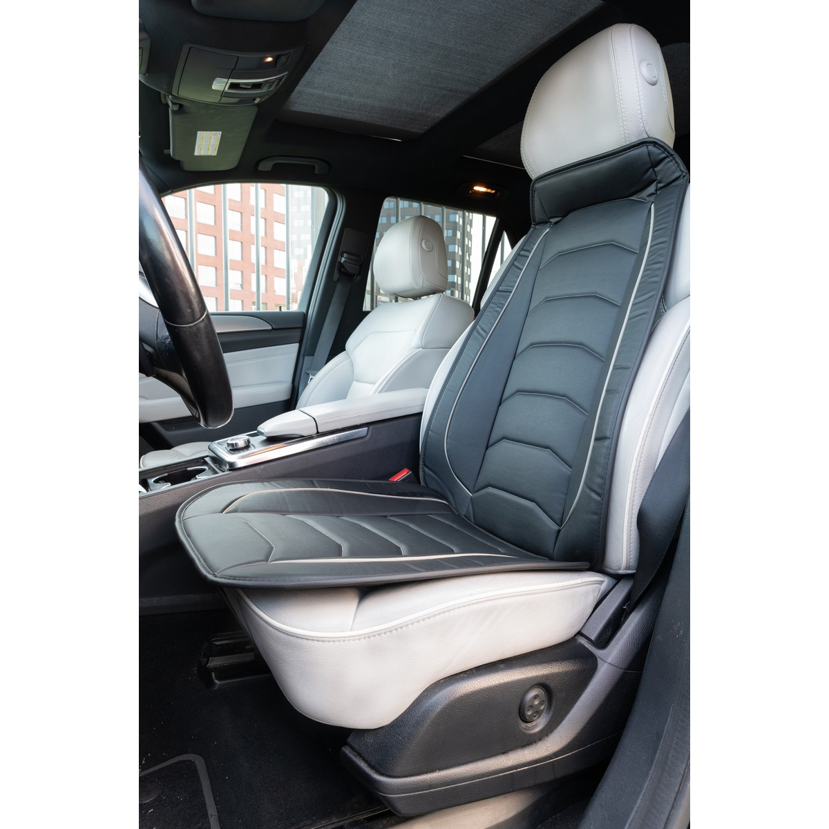 Car interior with black and gray seat covers, steering wheel visible.