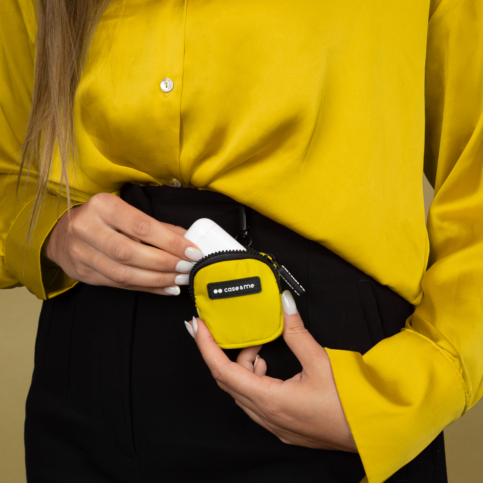 Funda amarilla con auriculares, sostenida por una mujer con camisa amarilla.