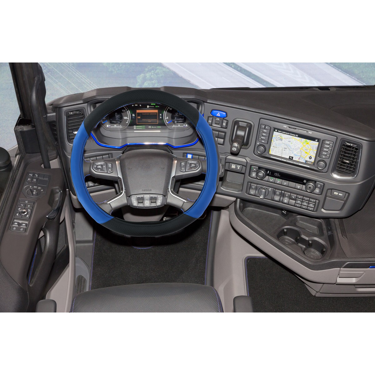 Truck interior: blue and black steering wheel cover, dashboard with screens and controls.