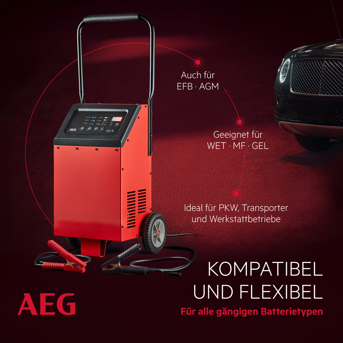 Rotes Ladegerät mit Rädern, Kabeln und Klemmen, neben einem Auto.