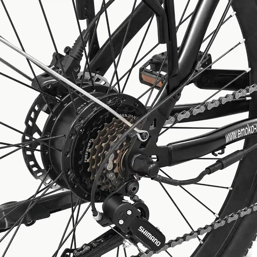 Primo piano della ruota posteriore, degli ingranaggi e della catena di una bicicletta nera.