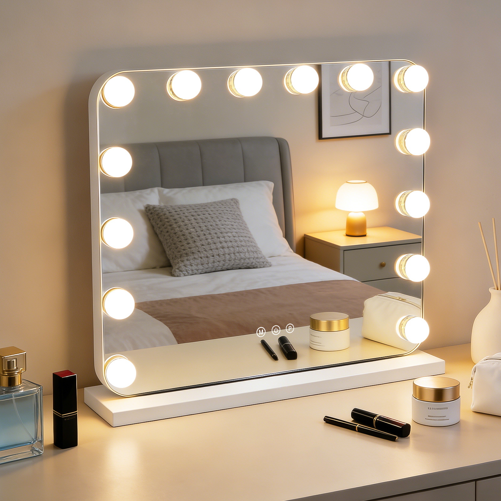 Un espejo de tocador iluminado se sienta sobre una cómoda frente a una cama. Hay maquillaje.