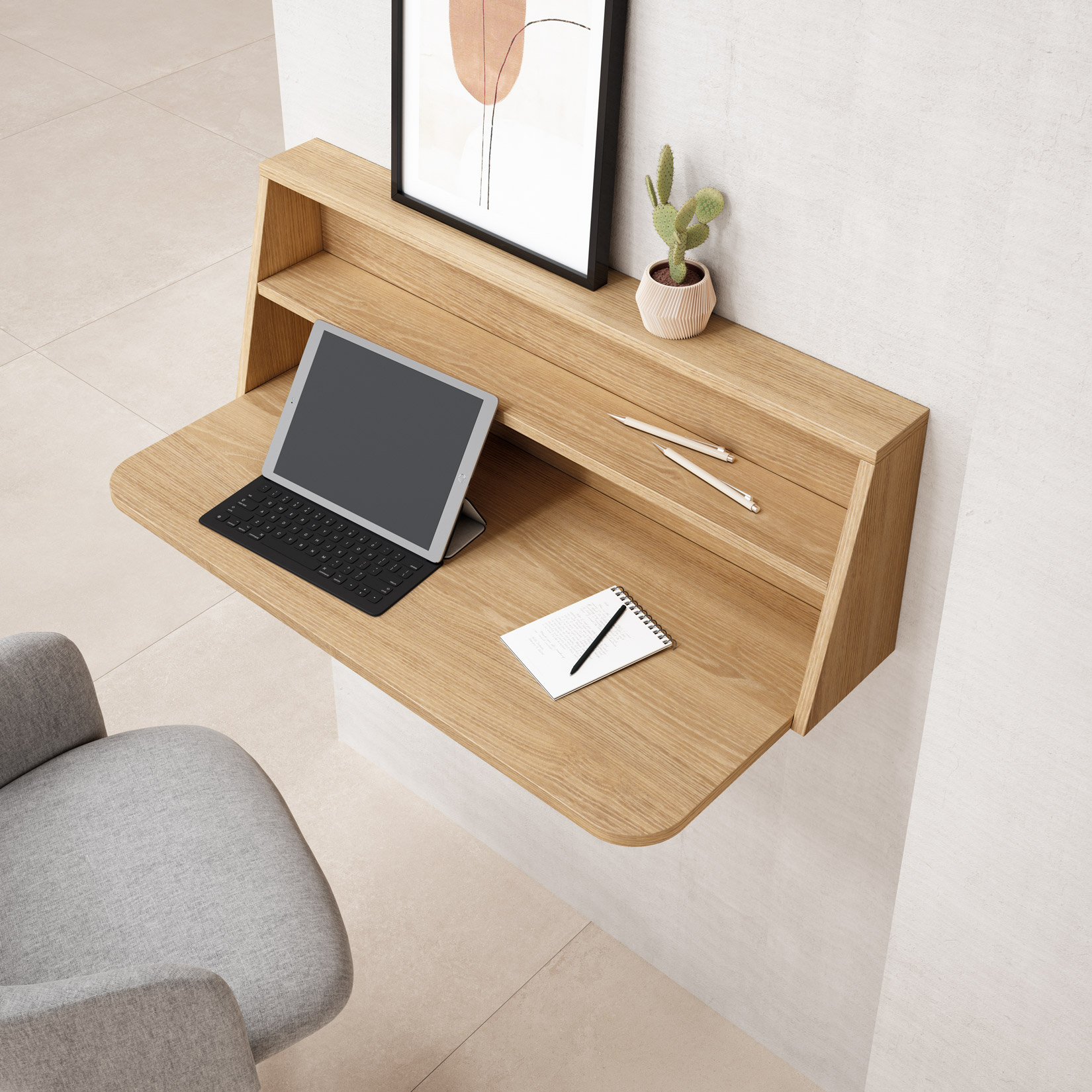 Un escritorio de madera de pared con tableta, teclado, cuaderno y bolígrafos.