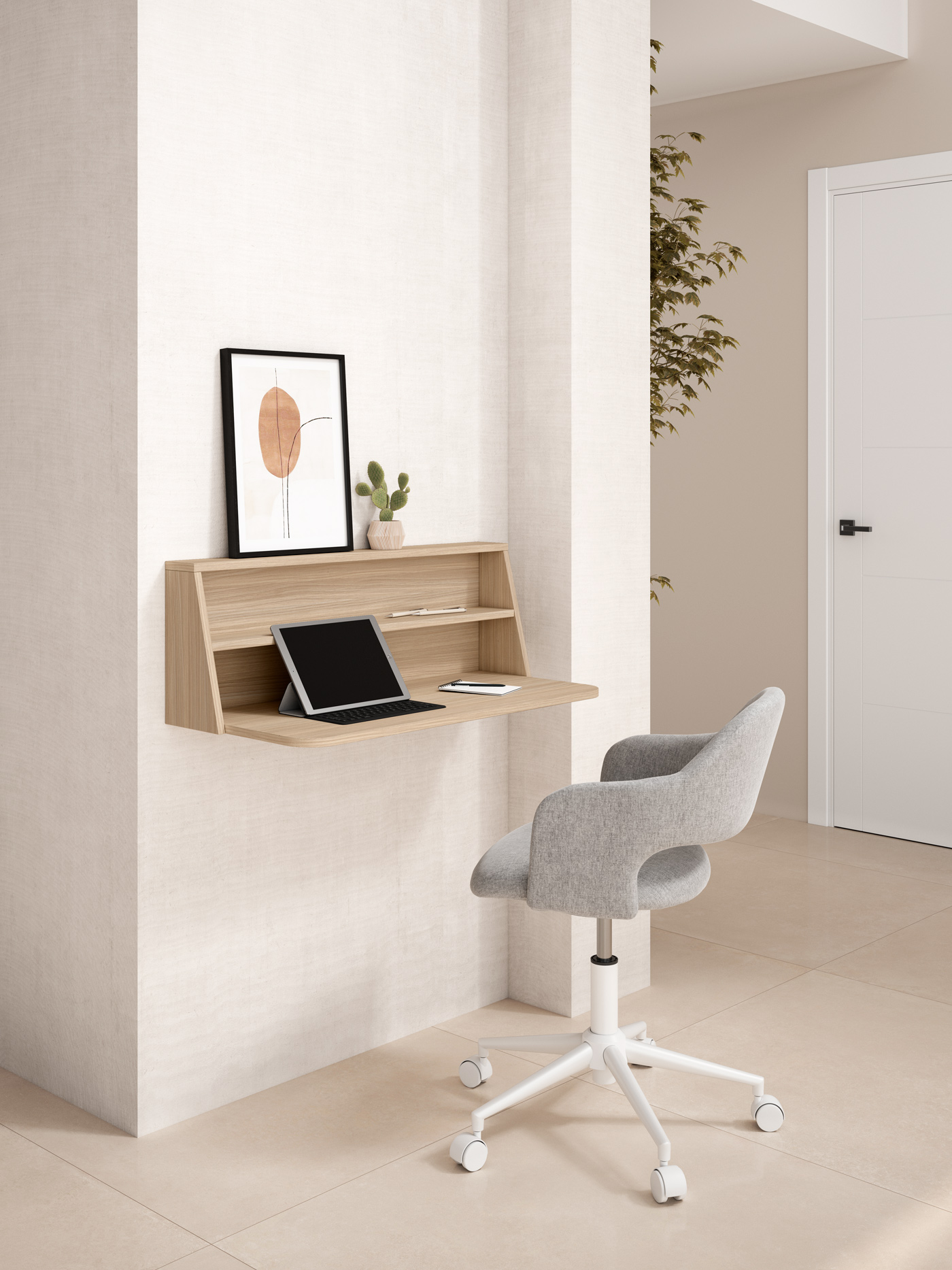 Un escritorio de pared de madera con tablet, cactus y cuadro. Silla gris delante.
