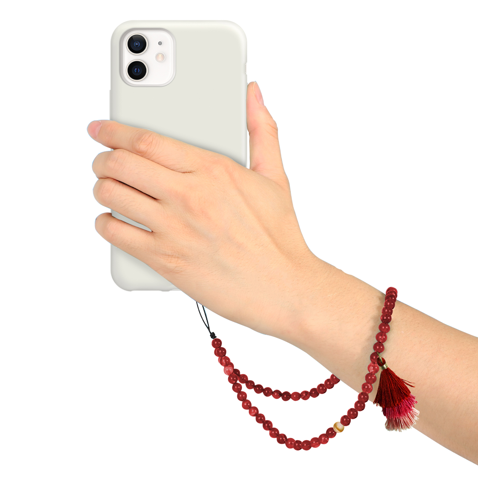 Una mano sujeta un smartphone gris claro. Una pulsera de cuentas rojas con borla está en la muñeca.