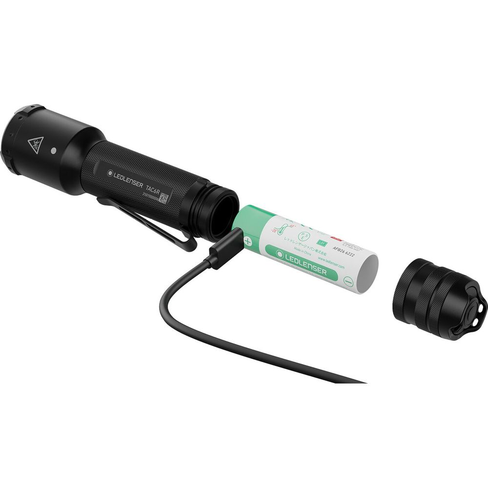 Schwarze Taschenlampe wird mit einem grünen Akku verbunden, der an ein Kabel angeschlossen ist.