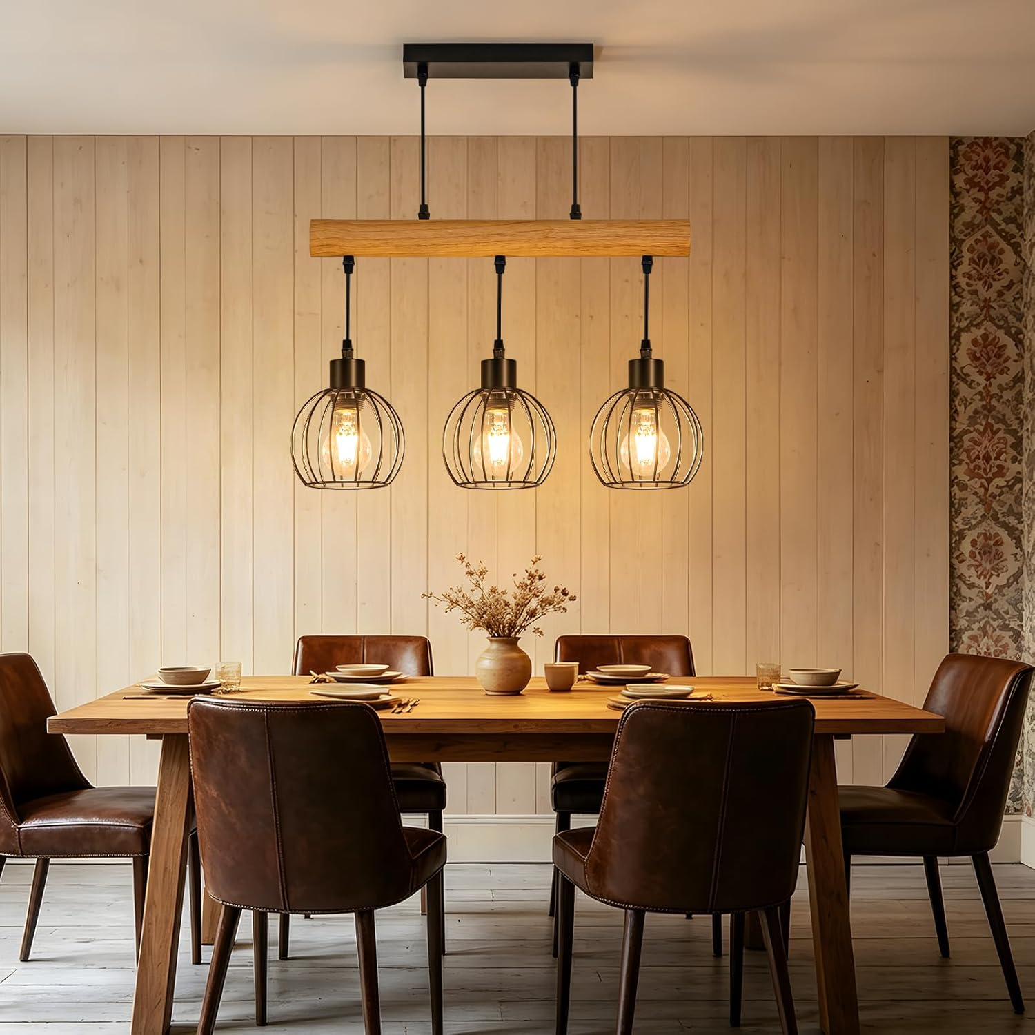 Holztisch mit braunen Ledersesseln und drei Pendelleuchten mit Drahtkörben.