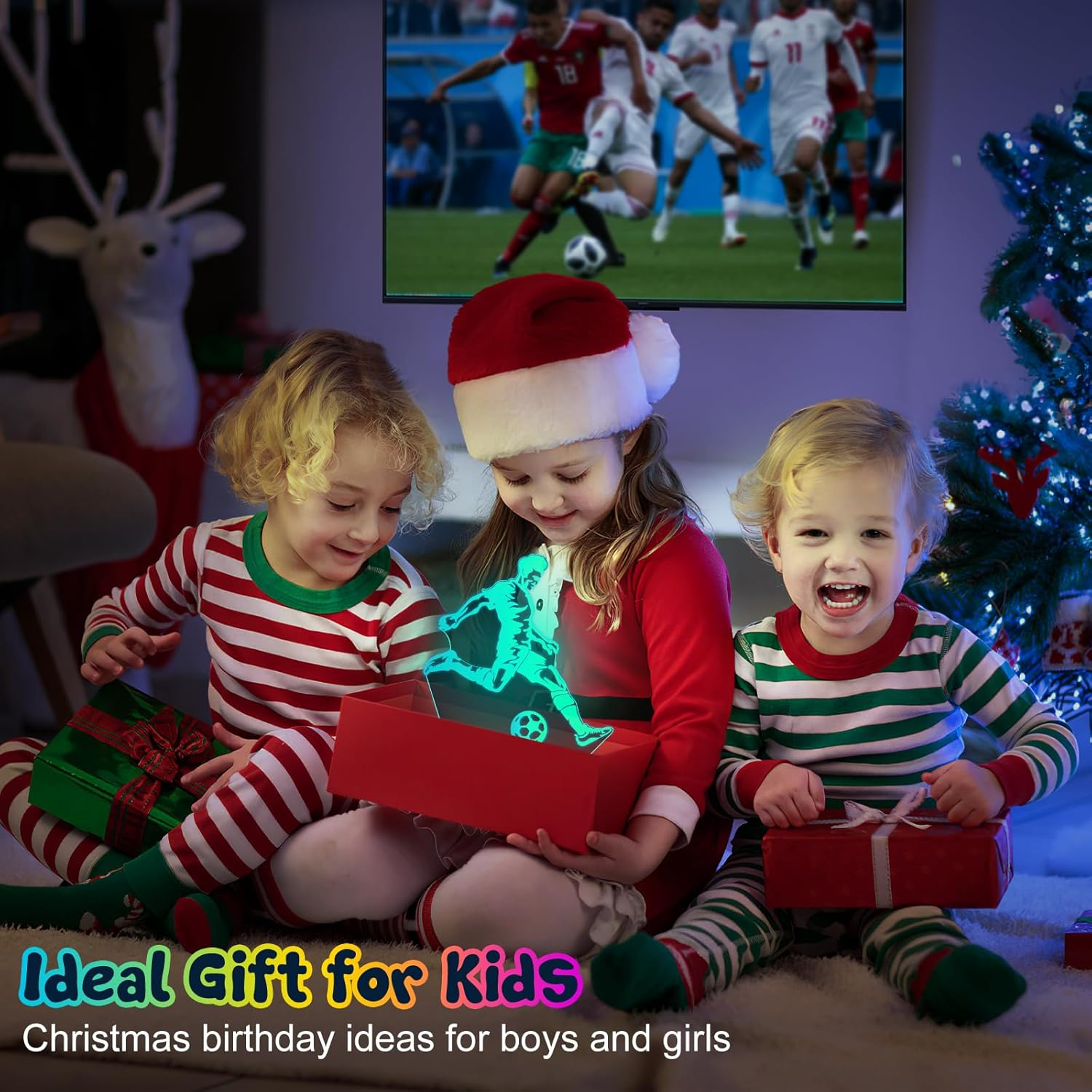 Drei Kinder mit Weihnachtsgeschenken vor einem Fernseher, der Fußball zeigt.