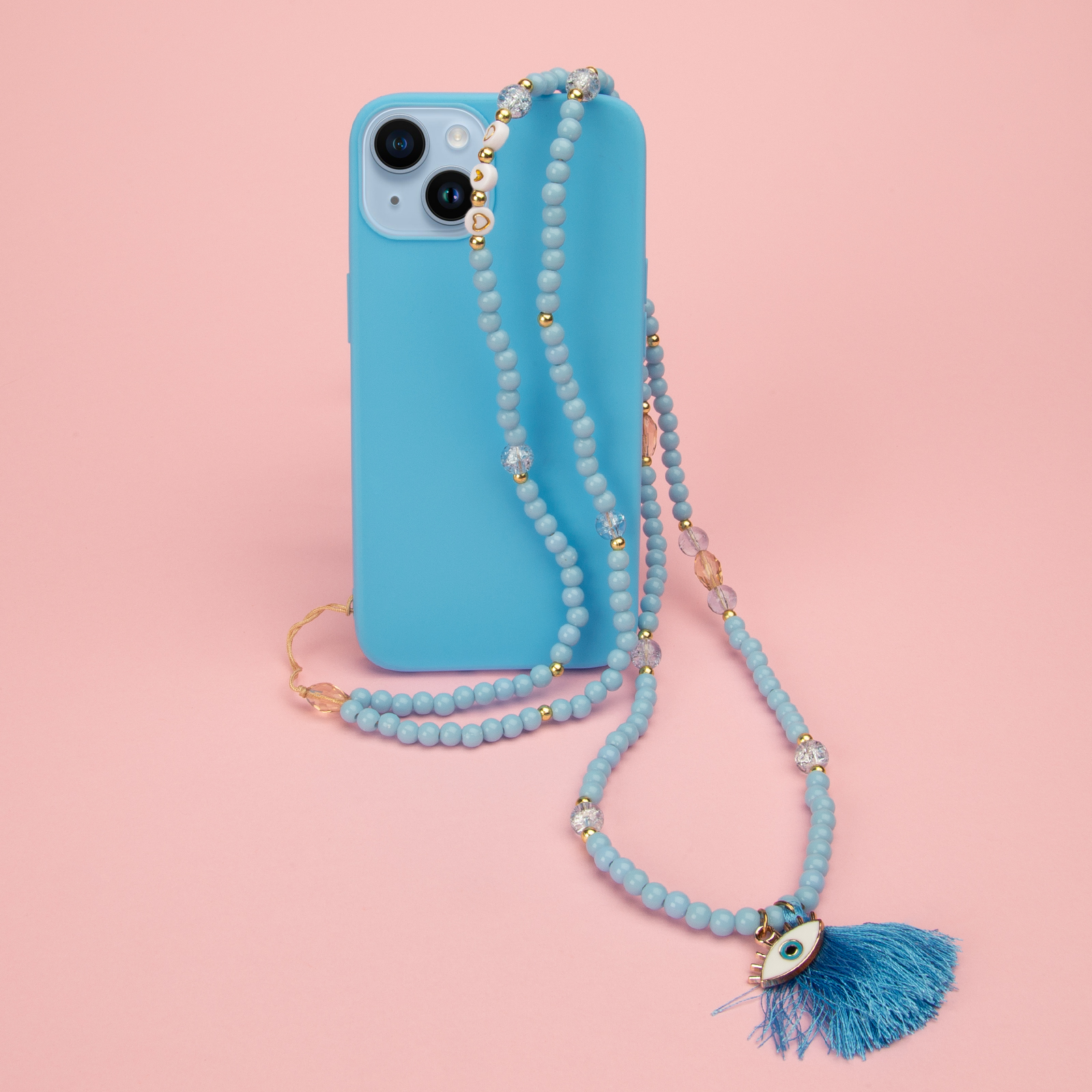 Un teléfono azul claro con un collar de cuentas y un amuleto de ojo con borla.