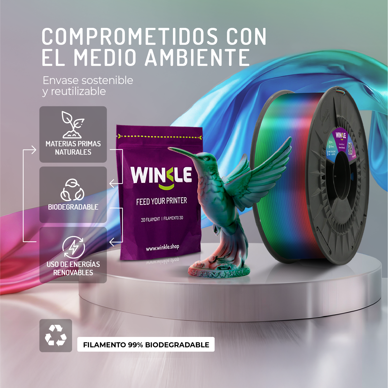 Un colibrí verde se cierne sobre un carrete de filamento multicolor para impresión 3D.