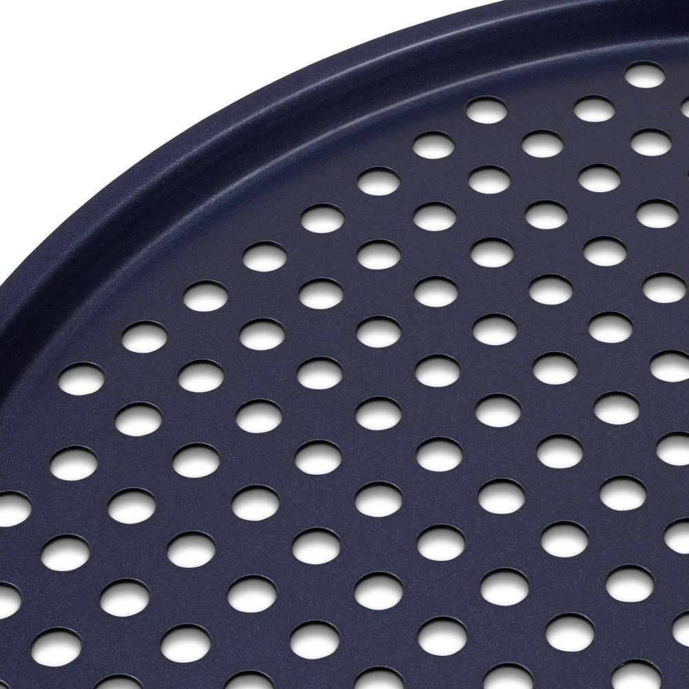 Dunkelblaue Grillplatte mit vielen runden Löchern im Detail.
