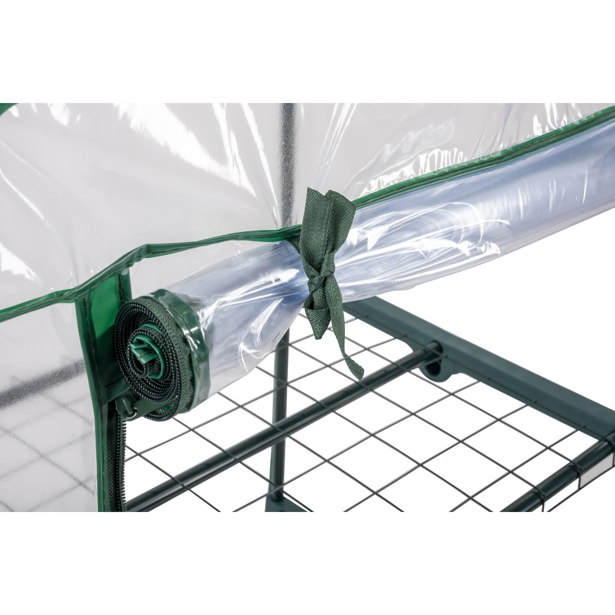Green greenhouse frame with rolled-up clear cover secured by a tie.