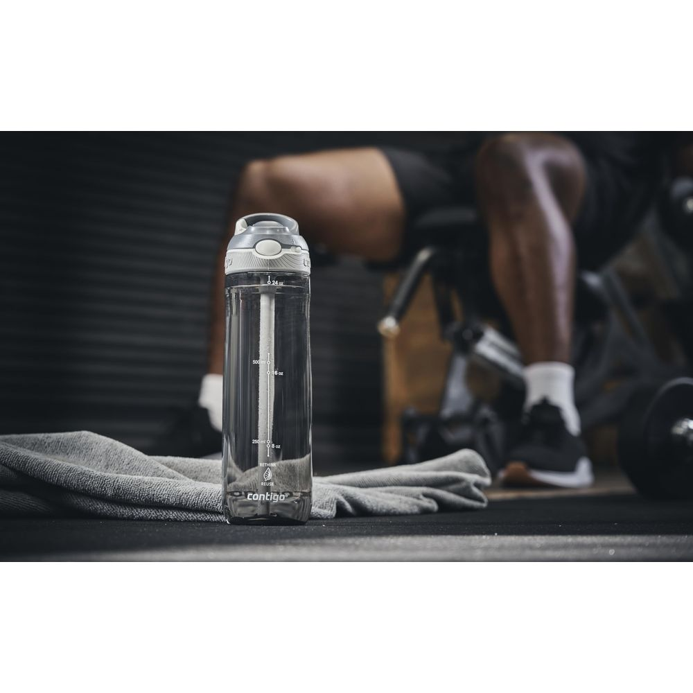 Eine klare Wasserflasche mit Strohhalm steht auf einem Handtuch im Fitnessstudio.