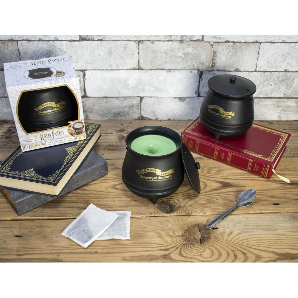 Ein Harry Potter Topf-Becher mit grünem Inhalt steht auf einem Holztisch.