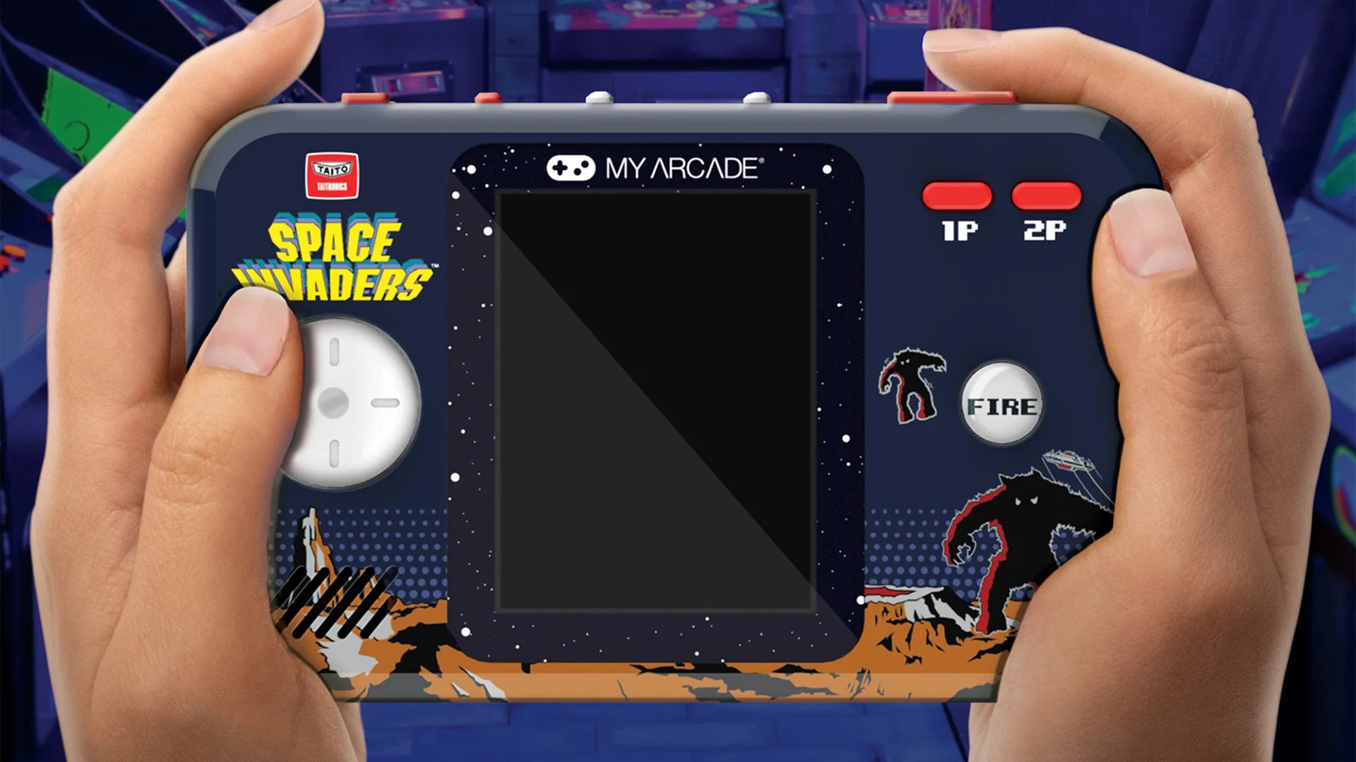 Eine Person hält ein blaues Handheld-Spielgerät mit Weltraum-Invader-Grafik.