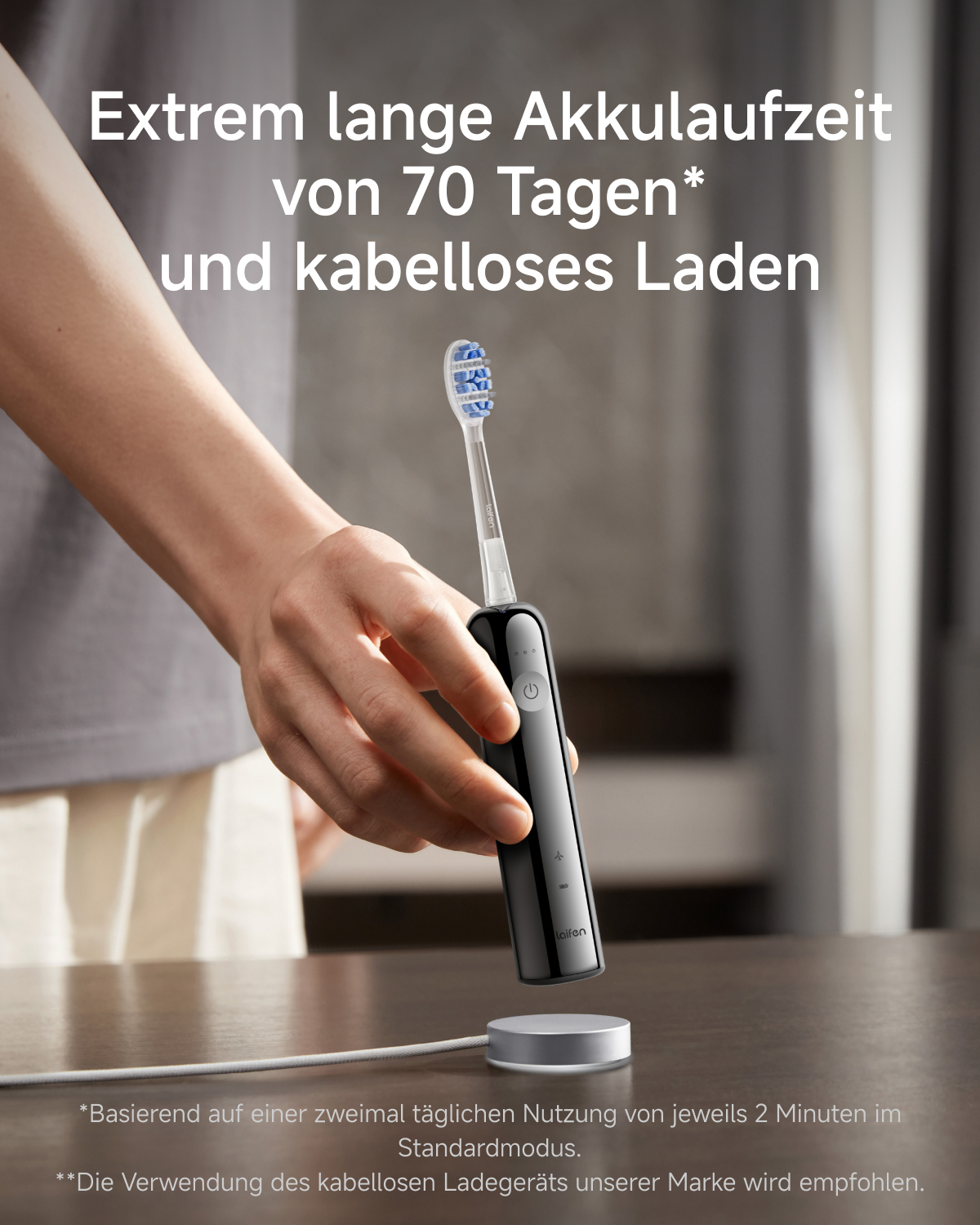 Eine Hand hält eine schwarze elektrische Zahnbürste über eine Ladestation.