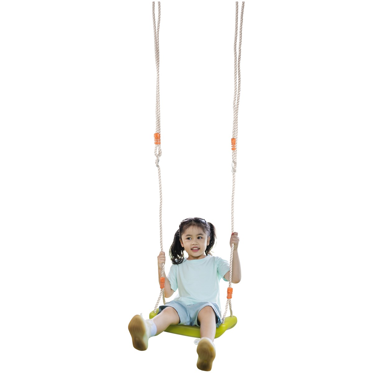 A young girl with pigtails sits on a green swing, smiling.