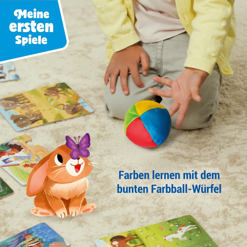 Bambino gioca con puzzle colorati e una palla di stoffa su un tappeto.
