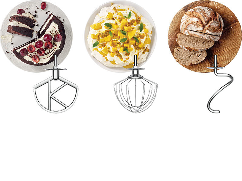 Drei Küchenmaschinenaufsätze mit Desserts: Schokoladenkuchen, Pavlova, Brot.
