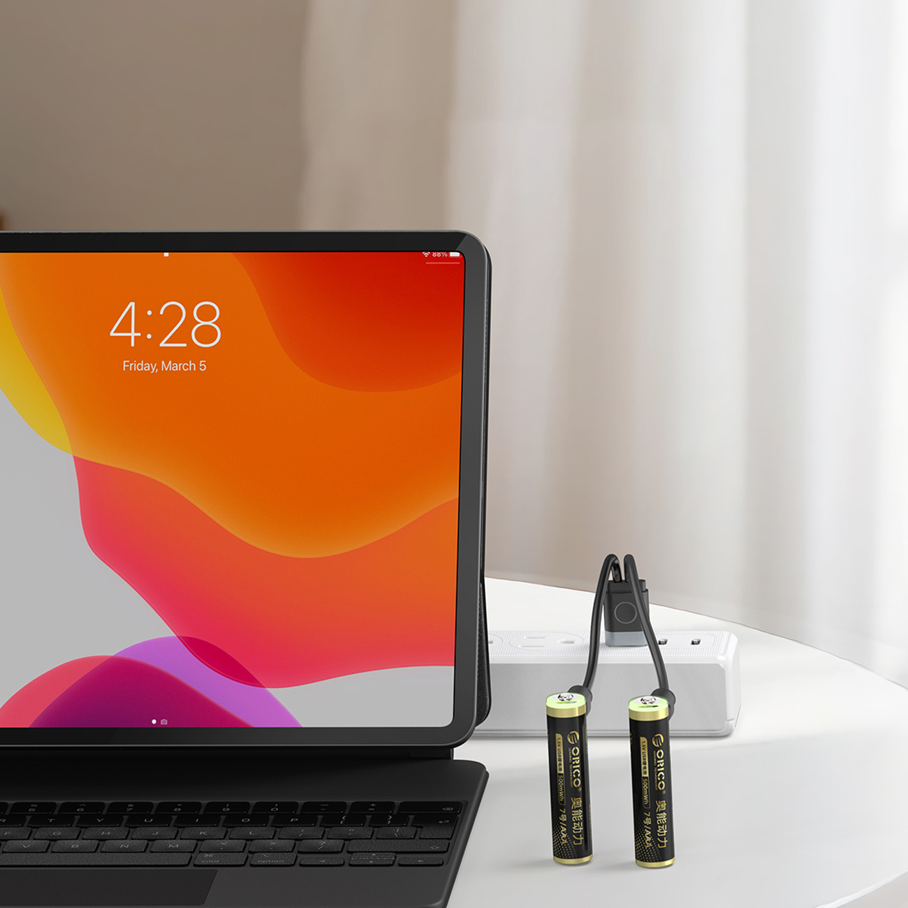Tablet z klawiaturą i dwie baterie AAA podłączone do listwy zasilającej.