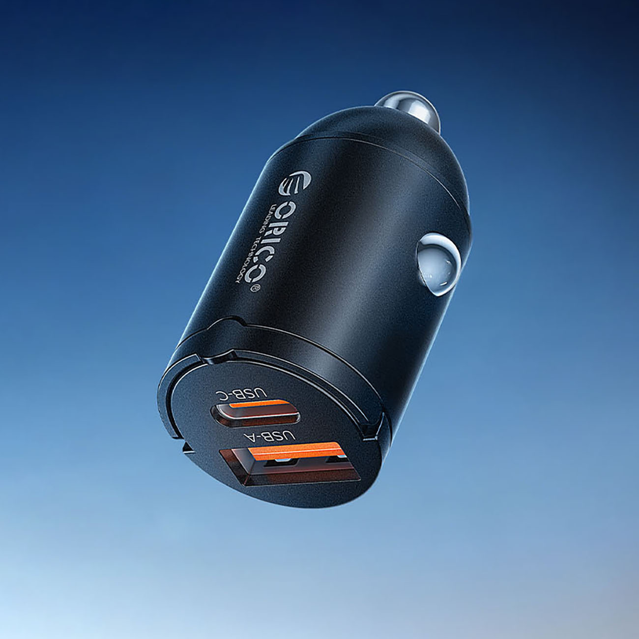 Czarna ładowarka samochodowa z portami USB-A i USB-C, na tle niebieskiego nieba.
